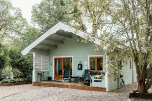 a small green house with a porch and a patio at Bazare Log Cabin, Whinstone View in Great Ayton