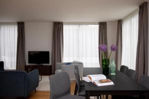 ロンドンにあるBob W Tower Hill Residencesのテーブルと椅子とテレビのあるリビングルーム