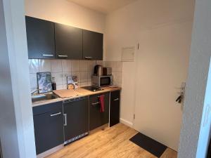 a small kitchen with a sink and a microwave at Five O - FeelGood -Apartment Schiller in Perleberg