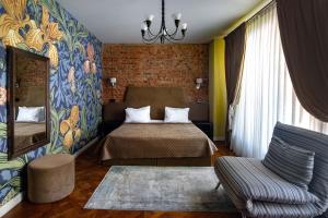 a bedroom with a bed and a chair and a mirror at Shato Luxe in Odesa