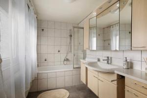 Un baño con lavabo, bañera y ducha. en Mb Homes Nürtingen Fewo1, en Nürtingen 17 fotos más