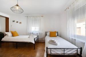 2 camas en una habitación con almohadas blancas y naranjas en Mb Homes Nürtingen Fewo1, en Nürtingen