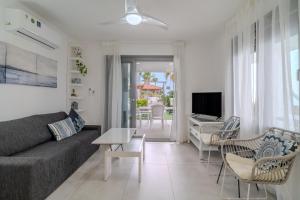 a living room with a couch and chairs and a television at Beachfront Meneou Blu 2 Bedrooms Beach House in Meneou