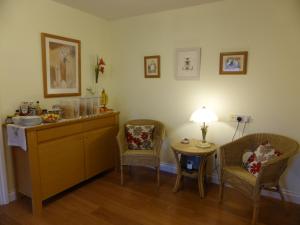 um quarto com duas cadeiras e uma mesa com um candeeiro em Liongate House em Ilchester