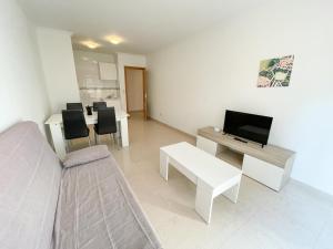 Televízia a/alebo spoločenská miestnosť v ubytovaní Apartamentos Playa de la Lanzada 3000