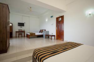 a bedroom with a bed and a couch in a room at Hotel Oviya in Vavuniya