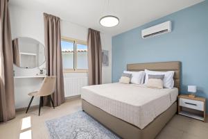 a bedroom with a white bed and a window at Harmonia Luxury Villa by Nomads in Peyia +17 photos