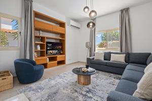 a living room with a blue couch and a table at Harmonia Luxury Villa by Nomads in Peyia