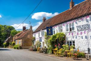 une rangée de maisons avec tables et chaises dans une rue dans l'établissement Ken Hill Cottage, à Snettisham