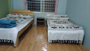 a room with two beds and a window at Sakar home stay in Pokhara