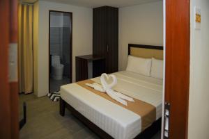 a bedroom with a bed with a white towel on it at Kaia Isabelle Hotel Puerto Princesa in Puerto Princesa City