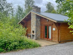 a small log cabin with a porch and a chimney at Bamboo 54 in Oignies-en-Thierache