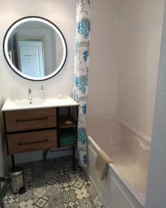 a bathroom with a sink and a tub and a mirror at Magnifique T2 standing piscine proche mer in La Ciotat