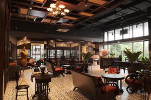 a restaurant with tables and chairs in a room with windows at Saigon Sirius in Ho Chi Minh City