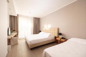 a hotel room with two beds and a television at D'Aragona Lifestyle Hotel in Conversano