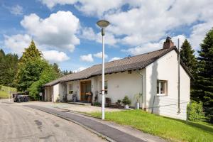 ein weißes Haus am Straßenrand in der Unterkunft Ferienresidenz Gartentraum Titisee in Titisee