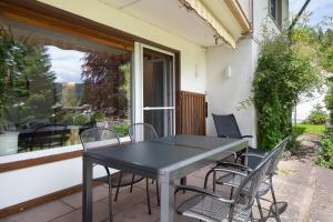 ein schwarzer Tisch und Stühle auf einer Terrasse in der Unterkunft Ferienresidenz Gartentraum Titisee in Titisee