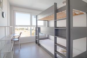 a room with bunk beds and a table and a chair at Global Properties, Moderno apartamento con gran terraza y vistas al mar in Canet de Berenguer +63 photos
