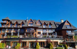 a large building with a roof at Mountain Palace Tatra Resort & SPA in Kościelisko