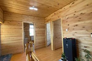 ウルギーにあるNature's Rest Lodgeの木製の壁の客室で、冷蔵庫が備わります。 +5枚の写真