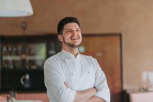 a man in a white shirt standing in a kitchen at Hotel - Restaurant Soleo in Krumpendorf am Wörthersee