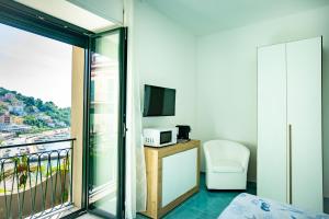 a room with a balcony with a bed and a television at Terrazza Sanfelice in Agropoli