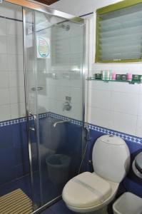 a bathroom with a toilet and a glass shower at Mountain Club Resort Munnar in Chinnakanal