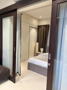 a bedroom with a bed and a mirror at Hawana Salalah Resort - Acacia 7 in Ţāqah +6 photos