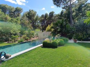 a swimming pool in a yard with a garden at La Petite perle, balnéo en supplément, le Clos des Perles in Tourtour