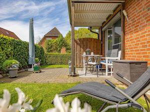 a patio with a table and chairs in a yard at Ferienwohnung Seebergweg in Maasholm-Bad