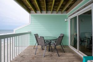 a table and chairs on a balcony with the ocean at Oceanfront Condo with 3+ Pools - Ocean Dunes 1505 in Kure Beach
