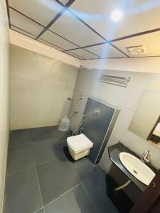 a bathroom with a toilet and a sink at Hotel Sandalwood Inn - Rooms and Spa in Bengaluru +21 photos