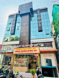 a building with a lot of motorcycles parked in front of it at Hotel Sandalwood Inn - Rooms and Spa in Bengaluru