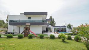 a house with a playground in front of a yard at VILLA PAOLA in Polača