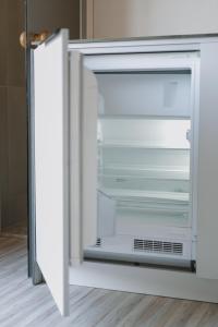 an empty refrigerator with its door open in a kitchen at ORE guest houses in Svenele