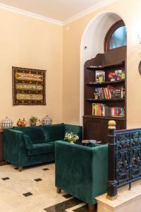 a living room with a green couch and a book shelf at Hotel Bella Casa in Tbilisi City