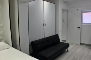 a black couch in a room with a bedroom at Work Stay in Gavà