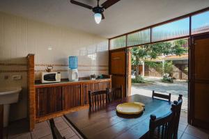 カボ・フリオにあるDuplex em Cabo Frio com Piscina e Garagem | CDI 28のキッチン(木製テーブル、椅子、電子レンジ付)