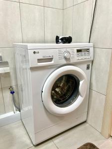 a washing machine in a corner of a room at Уютная 1 ком квартира Плаза, термопарк in Kostanay