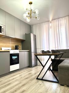 a kitchen with a table and a dining room at Уютная 1 ком квартира Плаза, термопарк in Kostanay