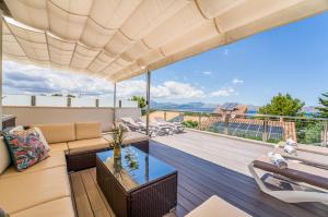 een woonkamer met een bank en een glazen tafel bij Ideal Property Mallorca - Xiscama in Alcudia