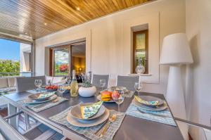 een eetkamer met een tafel, stoelen en ramen bij Ideal Property Mallorca - Xiscama in Alcudia