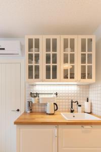 a kitchen with white cabinets and a sink at Egidijaus Vila in Nida