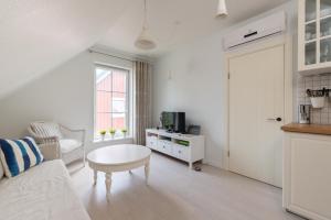 a white living room with a couch and a table at Egidijaus Vila in Nida