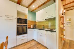 una cucina con mobili bianchi e pavimento in legno di Chalet pour 6 avec terrasse - 400m des pistes a Val-Louron Altre 9 foto