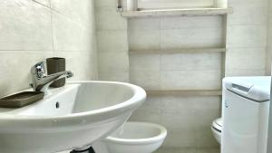 Un baño blanco con lavabo e inodoro. en N107 - Numana, villetta con giardino, en Numana 7 fotos más