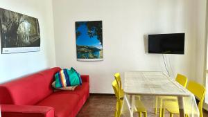 Una sala de estar con un sofá rojo y una mesa. en N107 - Numana, villetta con giardino, en Numana