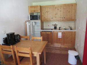 a kitchen with wooden cabinets and a wooden table at Résidence Les Alpages 4 étoiles - Appartement 4 personnes - Piscine, Hammam, Sauna, Jacuzzi - ValCenis 73480 in Lanslebourg-Mont-Cenis