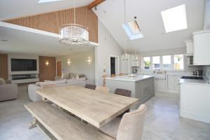a large kitchen and dining room with a table and chairs at Stylish home with HOT TUB in St Merryn