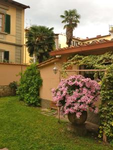 a vase filled with pink flowers next to a house at Casa Schlatter in Florence